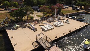 Une zone riveraine aménagée avec des chaises longues et un petit bateau amarré près de l’eau.