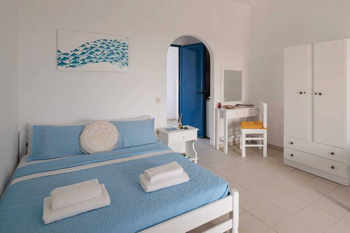 A bedroom with a bed, a desk, a chair, and a wardrobe.