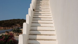 Un escalier blanc, avec des marches en pierre, mène à un bâtiment.