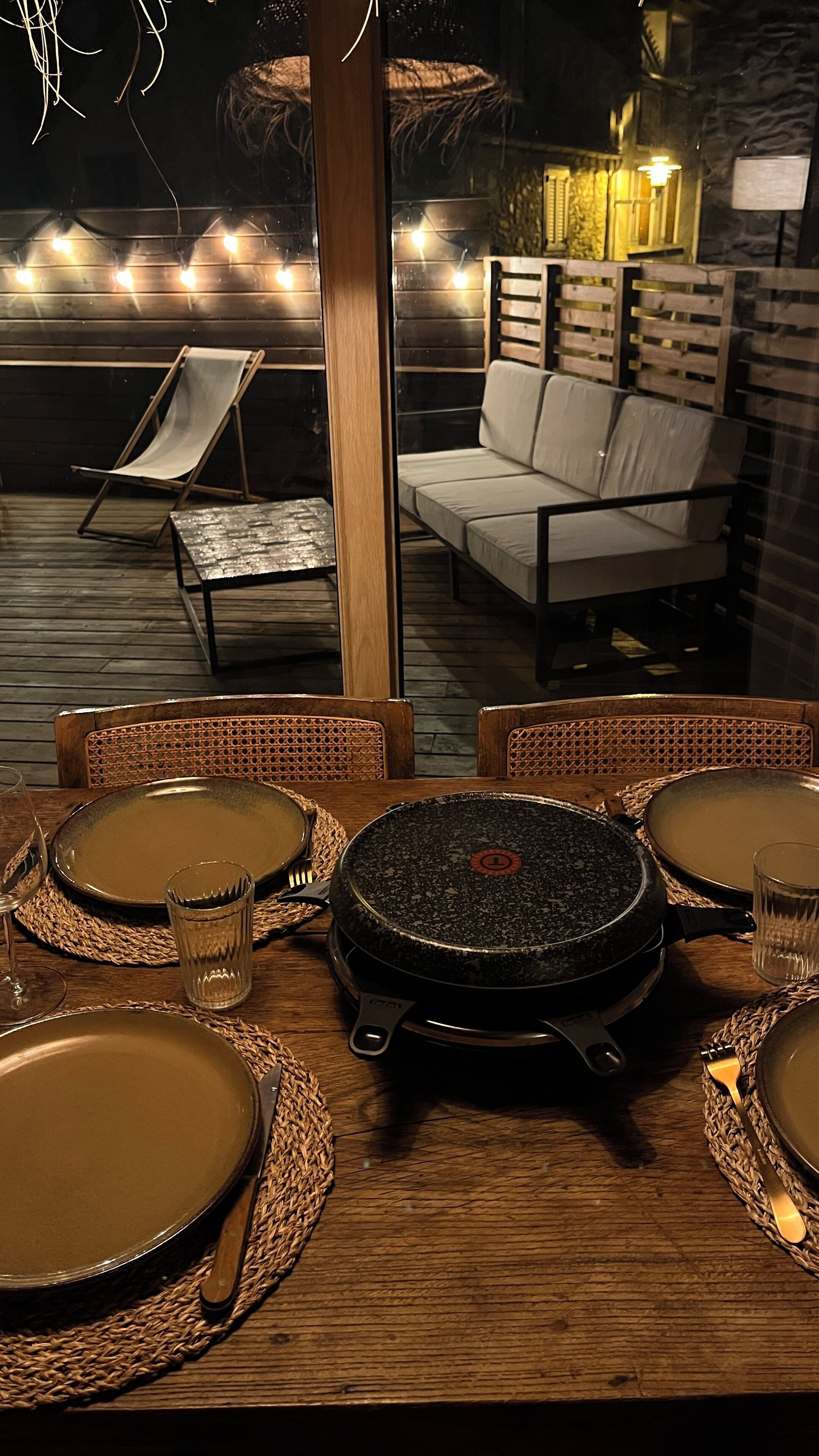 Un comedor con una mesa redonda, sillas y una parrilla.