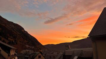 A residential area with houses and a mountain backdrop during sunset.
