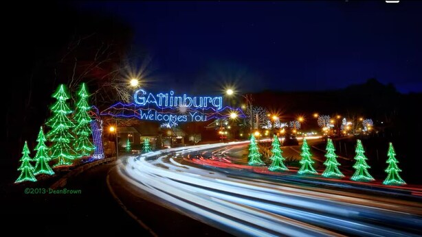A nighttime view of Gatlinburg with illuminated Christmas trees and a neon sign welcoming visitors. -  New Amazing View Cabin, 5 miles to Dollywood, 12 miles to Smokies, Sleeps 11 (Sevierville)