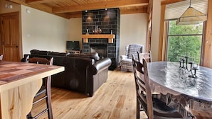 A cozy living area with a fireplace, a dining table, and a sofa.