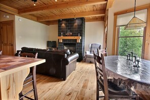 Una sala acogedora con chimenea, una mesa de comedor y un sofá.
