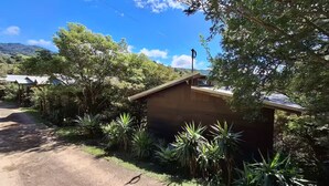A small, single-story building with a sloped roof, surrounded by lush greenery and trees. - villa sunset (Santa Elena)