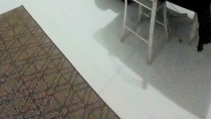 Sala de estar com sofá, televisão e escada.