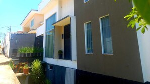 Uma casa moderna de dois andares com grandes janelas e uma varanda.