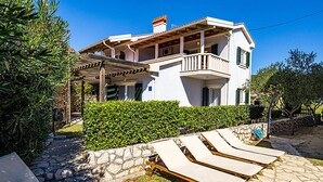 A two-story house with a balcony, a stone wall, and a swimming pool. - Nice apartment in Palit with swimming pool (Palit)