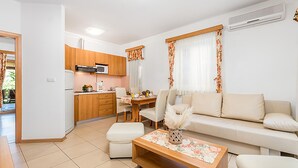 Een modern appartement met keuken, eethoek en woonkamer.