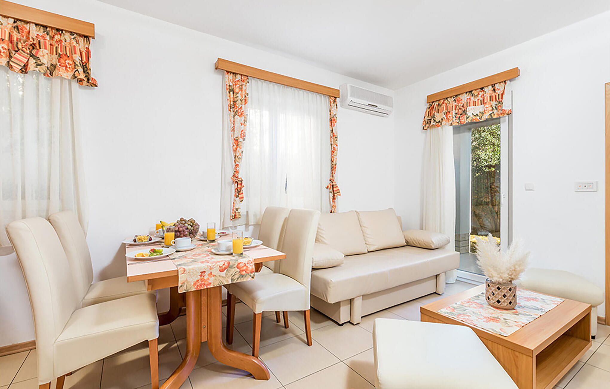 A modern living room with a dining table, sofa, and chairs.