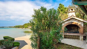 Uma propriedade costeira com cozinha externa de pedra e vista para o mar.