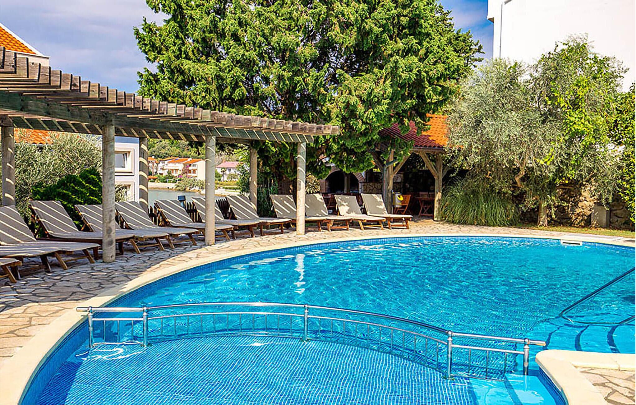 A swimming pool with lounge chairs and a pergola.