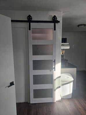 Une pièce dotée d’une porte coulissante donnant accès à une salle de bain.