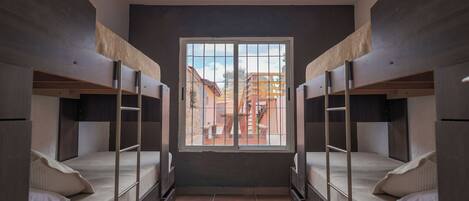 Un dormitorio con literas, un ventanal y vistas al exterior.