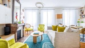 Un salon moderne avec une cheminée, un canapé, une table basse et une bibliothèque.