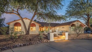 A two-story house with a patio area, large windows, and a stone pathway leading to the entrance. - The Sleepy Hollow Hideaway (Gold Canyon)