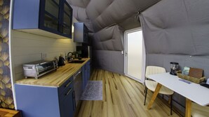 Una cocina compacta con armarios azules, una encimera de madera, un tostador y una cafetera.