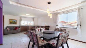 Un salon moderne comprenant un coin repas, un canapé, une table basse et un îlot de cuisine.