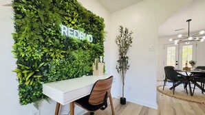A modern office space with a green wall, a desk, and a chair. - Redbud: Waterfront, Augusta Canal, 3BR, king bed (Augusta)