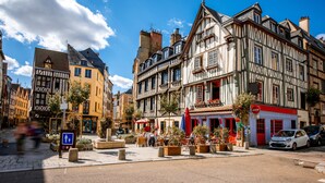 A street with historic buildings, outdoor seating, and a pedestrian crossing. - Le Lauroise, magnifique F2 place des Carmes (Rouen)