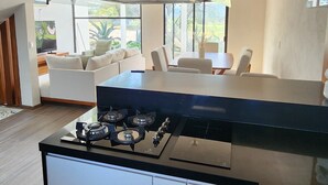 Una cocina moderna con una isla central, armarios empotrados y un amplio ventanal con vistas al exterior.
