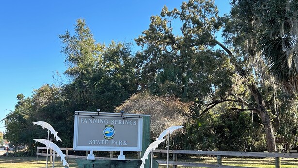 A sign for Fanning Springs State Park with a logo and two white bird sculptures on either side. - Fabulous private RV pad with full hookups, sewer and water located in Old Town (Old Town)