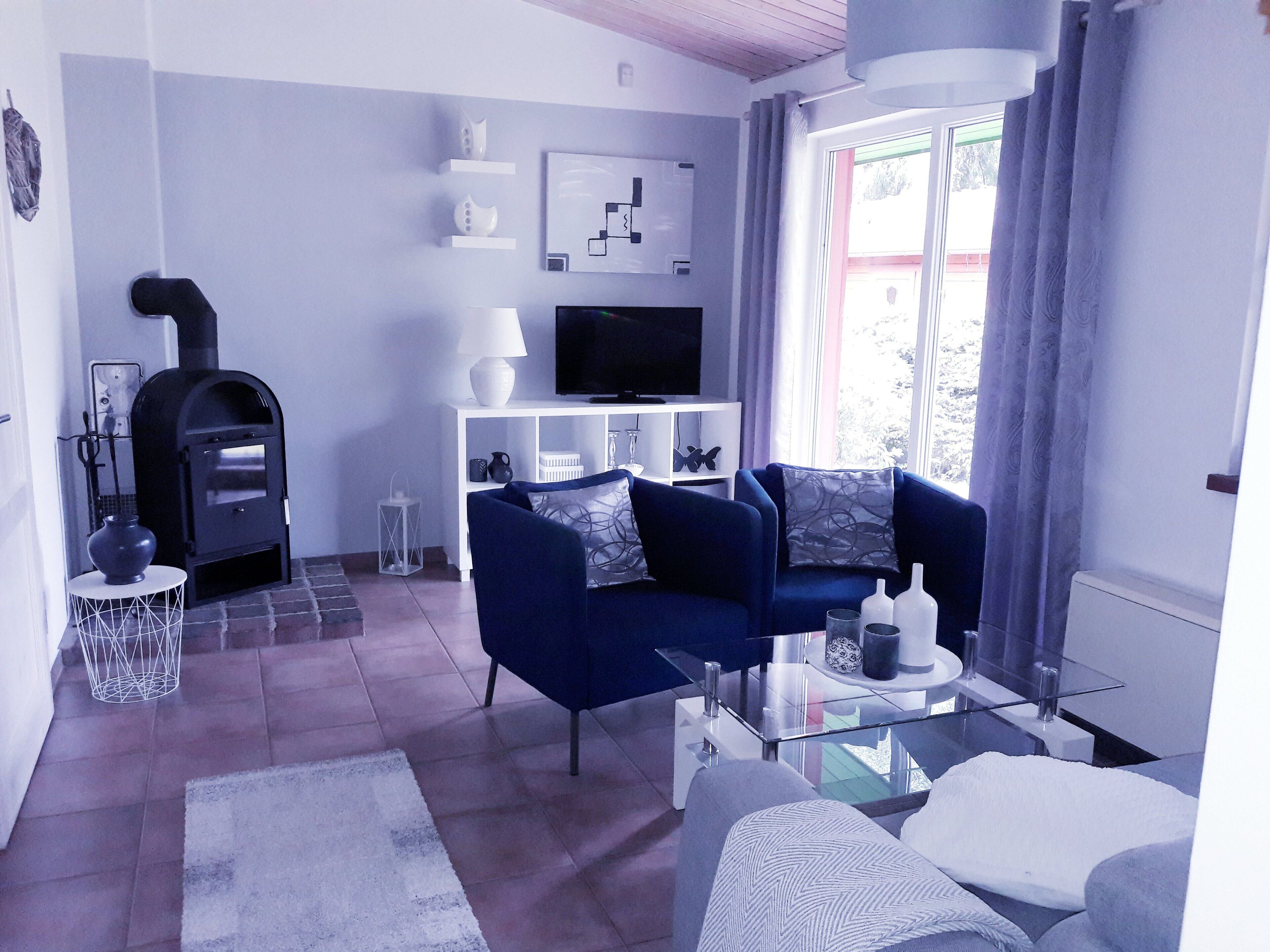 A modern living room with a fireplace, sofa, and TV.