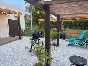An outdoor patio with a grill, seating area, and string lights. - Coastal Oasis / less than 1 mile to Nokomis Beach / Dog-Friendly FENCED YARD (Nokomis)