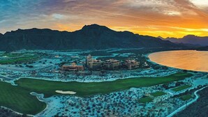 An aerial view of a coastal resort with multiple buildings, a golf course, and a large body of water. - 2-bedroom resort in fantastic Loreto with AC and fitness room (Loreto)