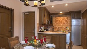 A dining area with a glass table, chairs, and a buffet setup. - 2-bedroom resort in fantastic Loreto with AC and fitness room (Loreto)
