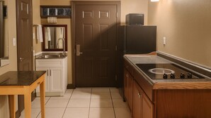 Une cuisine de taille réduite, équipée d’une cuisinière, d’un évier et de placards.
