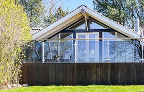 A modern house with a dark wooden exterior, a glass conservatory, and a triangular roof. - 4 bedroom gorgeous home in Tranekær (Tranekær)