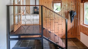 Un interno in legno con una scala, un camino e una finestra.