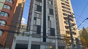 A multi-story building with a modern architectural design, featuring a mix of glass and concrete facades, and a prominent entrance with a glass canopy. - Melo Alves_31 2p / 1q (São Paulo)
