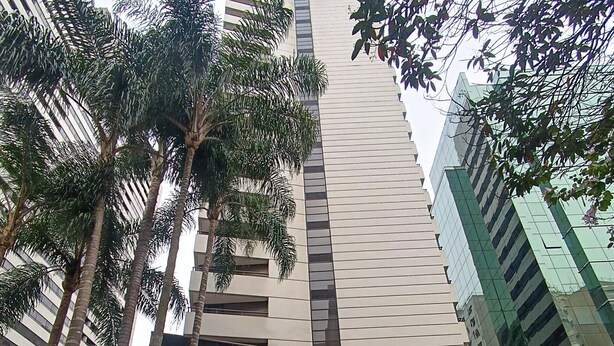 Moderni hotelli, jossa on selkeästi näkyvässä paikassa suuri «Mercure Hotel» -kyltti, pystysuuntainen julkisivu ja useita autoja mahtuva pysäköintialue.