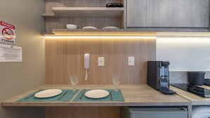 Une cuisine moderne dotée d’un plan de travail en bois, d’une machine à café et d’un four à micro-ondes.