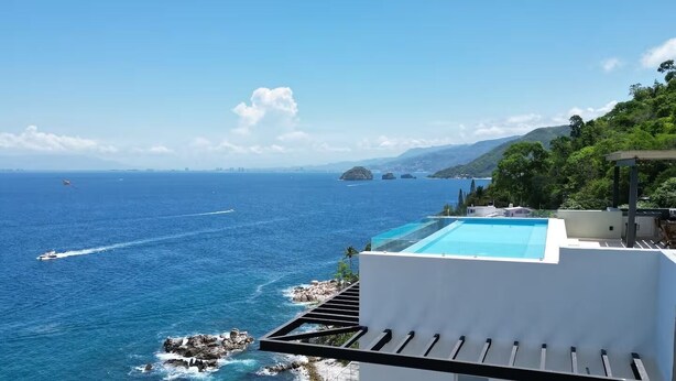 A pool overlooking a coastal area with a view of the sea and distant islands. - Luxury condo with Rooftop pool & Ocean views (Boca de Tomatlán)