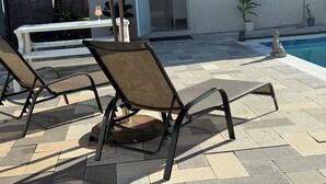 An outdoor seating area with chairs and a table under a canopy, near a pool and a building with a door and windows. - Modern Private Room -Super Clean and Quiet Stay (Miami)