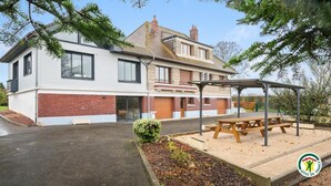 A two-story house with a covered outdoor seating area and a small garden. - Gîtes de France® - Villa des Champs (VILLERS SOUS FOUCARMONT)
