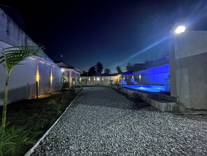 A pathway leading to a building with outdoor seating and illuminated walls. - Casa B. Pasco  Dauin , Guesthouse /Resort  Beach and amenity's  walking distance (Dauin)