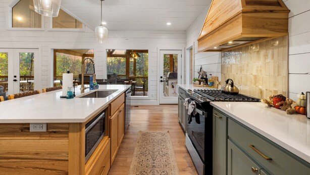 Una cocina amplia con una isla grande, armarios de madera y vistas al exterior.