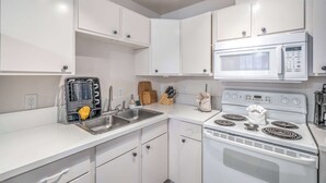 Una cocina moderna con armarios blancos, electrodomésticos de acero inoxidable y un horno empotrado.