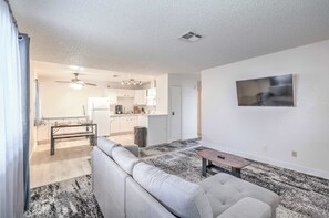 A modern living room with a sofa, a coffee table, and a TV mounted on the wall. - Vegas Adventure Starts Here-Mins to Strip! Sleep 6 (Las Vegas)