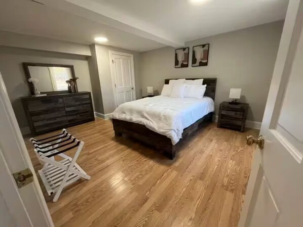A bedroom with a large bed, a dresser, a nightstand, and a chair. - Chesapeake Bay Retreat (Cambridge)