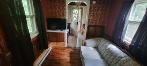 Un espacio habitable compacto con sofá, televisor de pantalla plana y un mueble de madera.