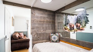 A bedroom with a wooden headboard, a bed with a quilted cover, and a mirror reflecting a forest scene. - Sunset Lover - Breathtaking Balcony Views, Sleeps 4, 15 Minutes Walk to Downtown (Gatlinburg)