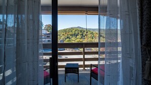 A balcony with a view of a hilly landscape, a small table, and a chair. - Sunset Lover - Breathtaking Balcony Views, Sleeps 4, 15 Minutes Walk to Downtown (Gatlinburg)