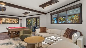 A modern living room with a pool table, a sofa, and a coffee table. - Dragonfly Landing on Beaver Lake, w/ hot tub (Rogers)