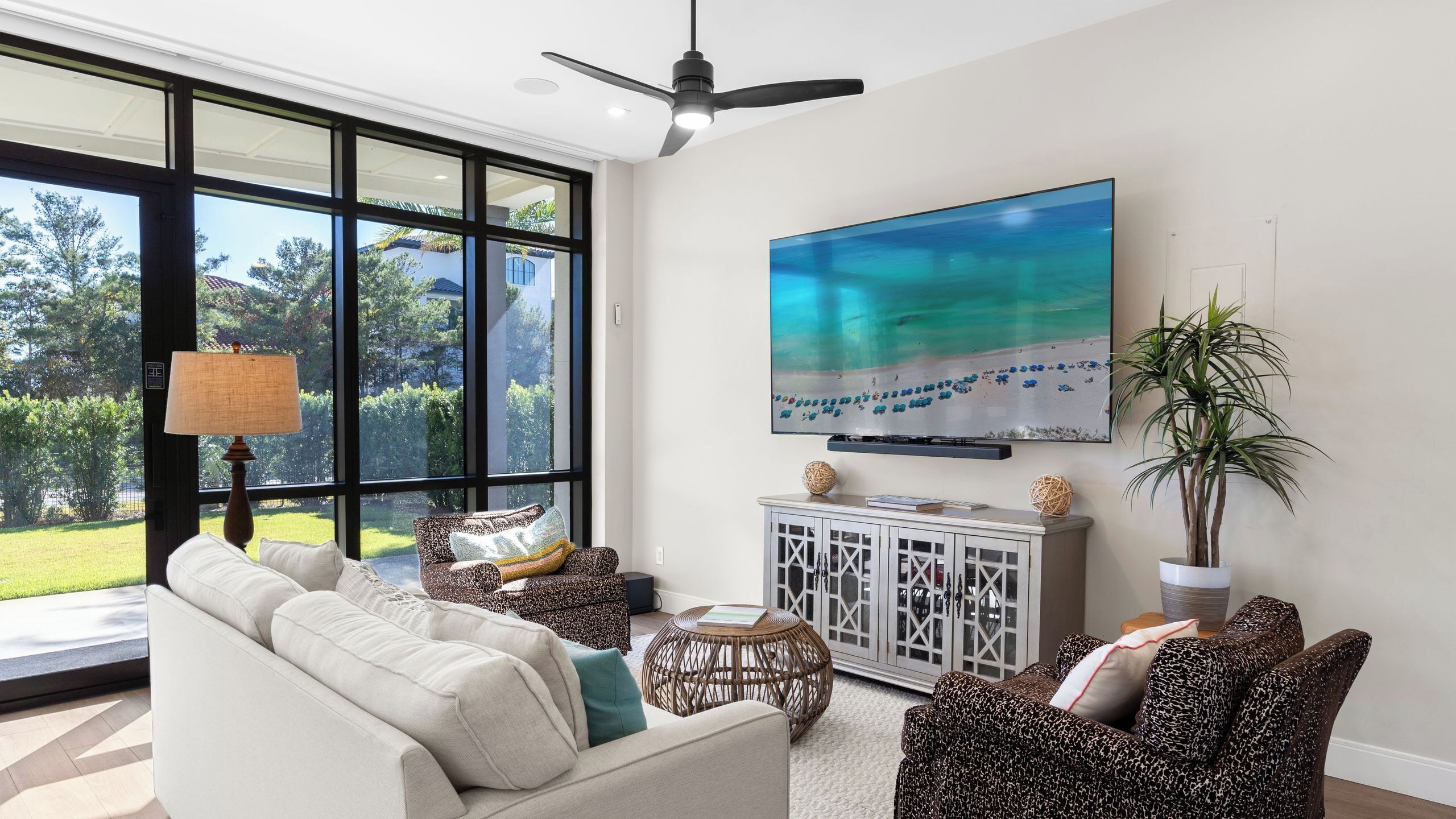 A living room with a large TV, a sofa, a coffee table, and a cabinet.