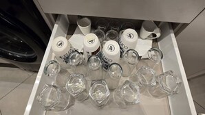 En skuffe med forskelligt glas og flasker, sandsynligvis til brug på et hotel.
